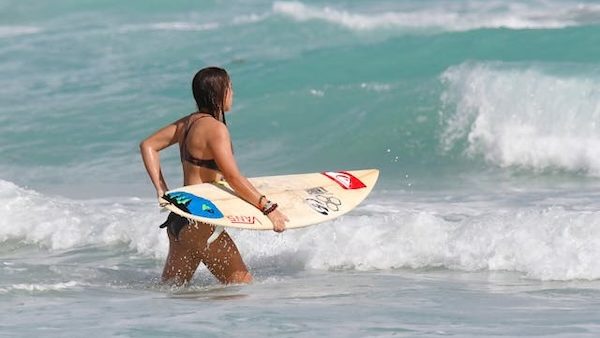 female surfer holding board in the water