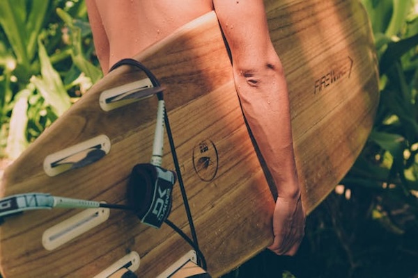 surfer holding branded surfboard