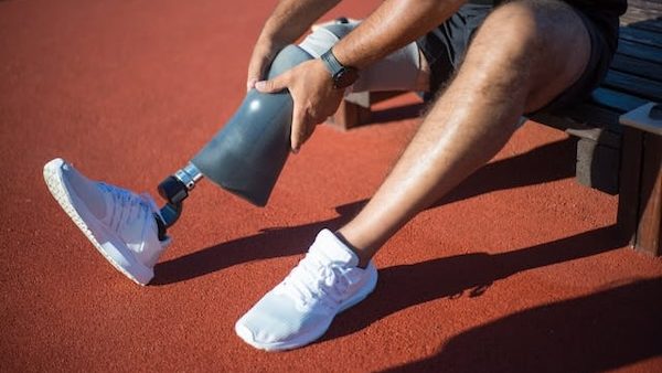 adaptive athlete putting on prosthetic leg for running