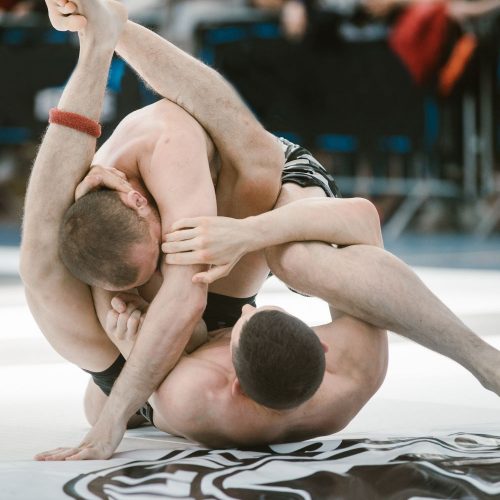 two men fighting in a jiu jitsu match, sports marketing agency
